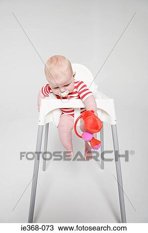 Stock Image - A baby girl in a high chair. Fotosearch