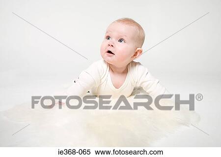 A baby girl lying on a rug View Large Photo Image Stock Photography - A baby girl lying on a rug. Fotosearch