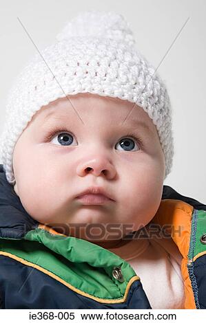 Stock Photography - A baby girl wearing a hat. Fotosearch
