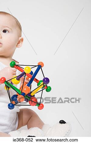 A baby holding a toy View Large Photo Image Stock Image - A baby holding a toy. Fotosearch