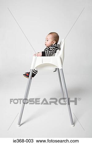 A baby in a high chair View Large Photo Image Stock Image - A baby in a high chair. Fotosearch