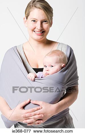 Stock Photo - A mother carrying her baby in a sling. Fotosearch