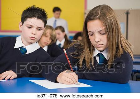 Boy looking at girls work View Large Photo Image Stock Photo - Boy looking at girls work. Fotosearch