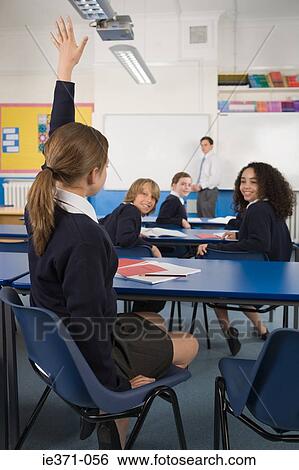 Girl in class with hand raised View Large Photo Image Stock Photograph - Girl in class with hand raised. Fotosearch