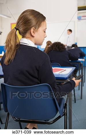 Girl with cellphone in classroom View Large Photo Image Stock Photo - Girl with cellphone in classroom. Fotosearch