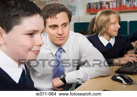 Teacher and pupils in computer class View Large Photo Image Picture - Teacher and pupils in computer class. Fotosearch