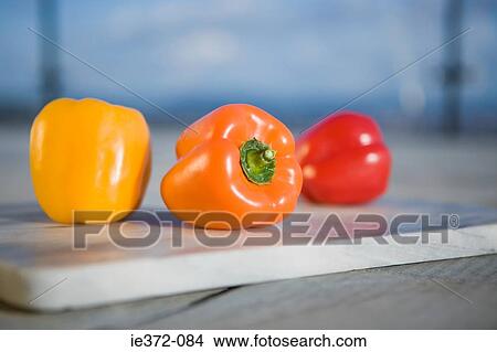 Picture - Peppers on chopping board. Fotosearch