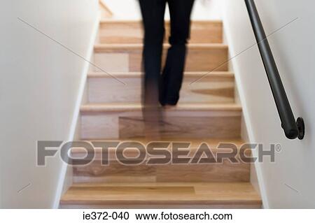 Stock Image - Person walking up steps. Fotosearch