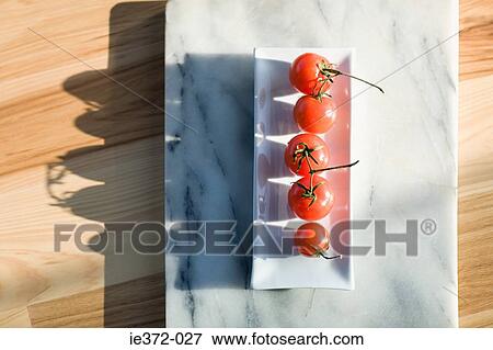 Tomatoes on a dish View Large Photo Image Stock Photo - Tomatoes on a dish. Fotosearch