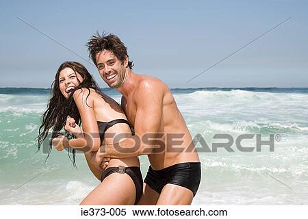 Stock Photography - Hispanic couple playing in the sea. Fotosearch