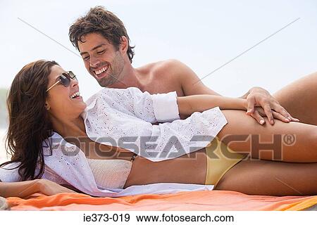 Stock Photo - Hispanic couple relaxing at beach. Fotosearch