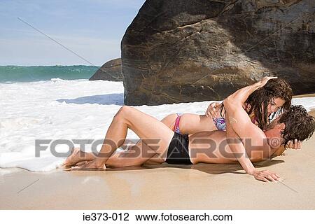 Intimate couple lying on a beach View Large Photo Image Stock Image - Intimate couple lying on a beach. Fotosearch