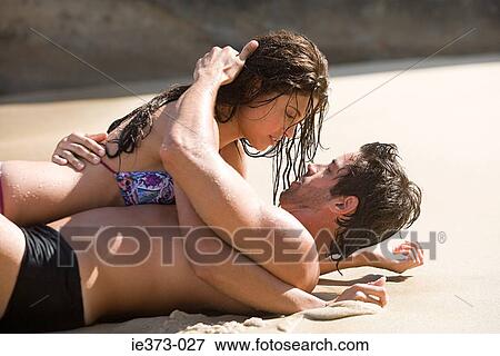 Stock Photo - Intimate couple lying on a beach. Fotosearch