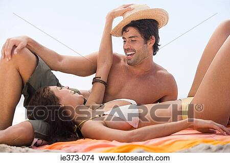 Young couple playing on a beach View Large Photo Image Picture - Young couple playing on a beach. Fotosearch