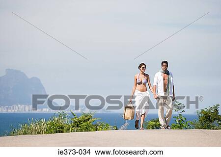 Picture - Young couple walking hand in hand. Fotosearch