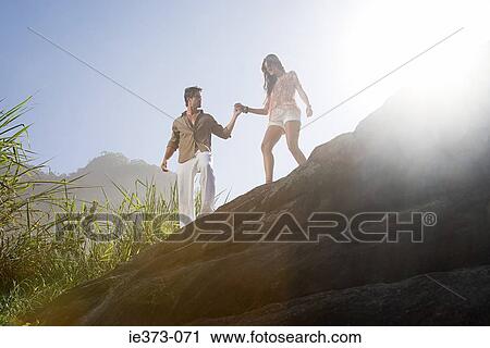 Young couple walking on rocks View Large Photo Image Stock Image - Young couple walking on rocks. Fotosearch
