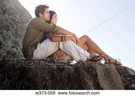 Young hispanic couple sitting on rocks View Large Photo Image Stock Photo - Young hispanic couple sitting on rocks. Fotosearch