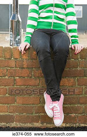 Stock Photography - Girl on wall with cigarette. Fotosearch
