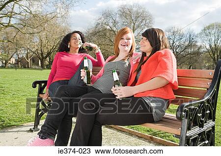 Girls on bench drinking beer View Large Photo Image Stock Image - Girls on bench drinking beer. Fotosearch