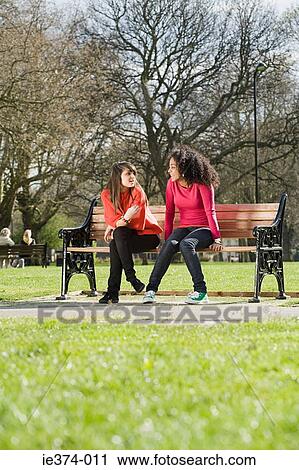 Girls sitting on a bench View Large Photo Image Stock Image - Girls sitting on a bench. Fotosearch
