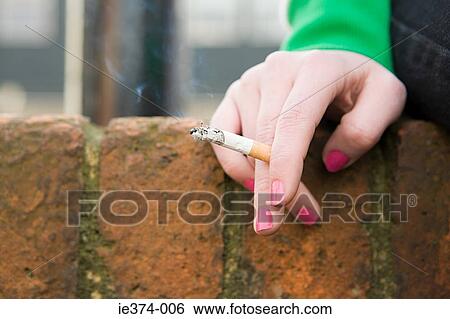Stock Photograph - Hand of a girl with cigarette. Fotosearch