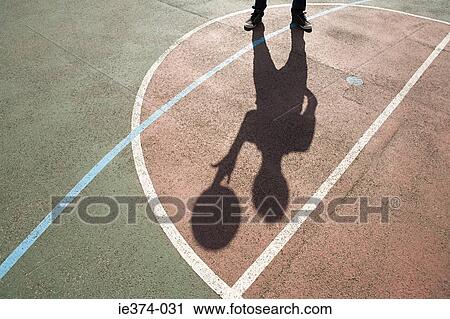 Stock Image - Shadow of person with basketball. Fotosearch