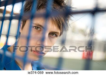 Teenage boy behind fence View Large Photo Image Stock Photo - Teenage boy behind fence. Fotosearch