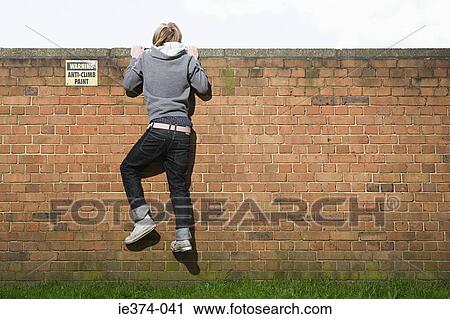 Teenage boy climbing wall View Large Photo Image Stock Image - Teenage boy climbing wall. Fotosearch
