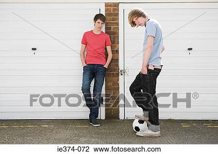 Stock Image - Teenage boys by garages. Fotosearch