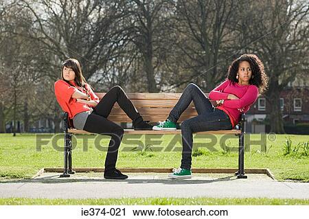 Stock Image - Teenage girls on bench. Fotosearch