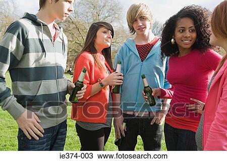 Stock Image - Teenagers in the park with beer. Fotosearch