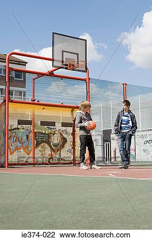 Two teenage boys on basketball court View Large Photo Image Stock Image - Two teenage boys on basketball court. Fotosearch