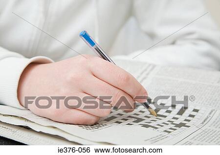 Stock Photograph - Person doing crossword. Fotosearch