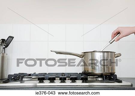 Person with saucepan on hob View Large Photo Image Stock Image - Person with saucepan on hob. Fotosearch