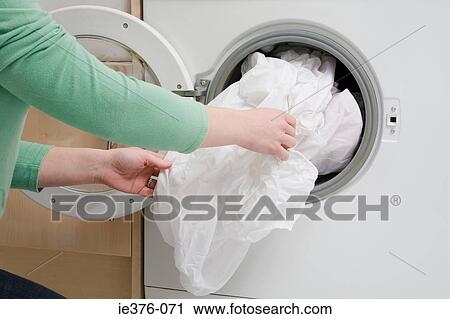 Woman taking sheet from washing machine View Large Photo Image Stock Image - Woman taking sheet from washing machine. Fotosearch