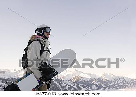 A woman holding a snowboard View Large Photo Image Stock Image - A woman holding a snowboard. Fotosearch