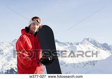 Portrait of a man holding a snowboard View Large Photo Image Stock Photo - Portrait of a man holding a snowboard. Fotosearch