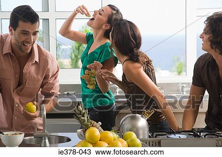 Friends eating fruit in kitchen View Large Photo Image Stock Image - Friends eating fruit in kitchen. Fotosearch