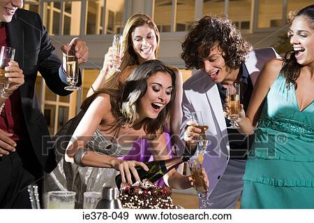 Woman pouring champagne at party View Large Photo Image Stock Photo - Woman pouring champagne at party. Fotosearch