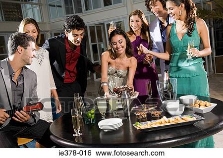 Woman preparing snacks at a party View Large Photo Image Stock Photograph - Woman preparing snacks at a party. Fotosearch