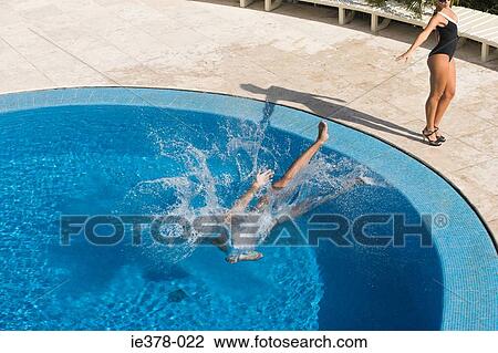 Woman pushing man in a swimming pool View Large Photo Image Stock Image - Woman pushing man in a swimming pool. Fotosearch