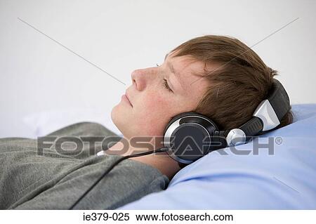A boy listening to his headphones View Large Photo Image Stock Photography - A boy listening to his headphones. Fotosearch