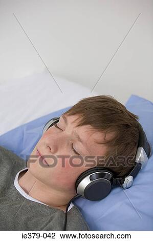 Stock Image - A teenage boy listening to music. Fotosearch