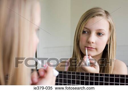 Stock Photography - A teenage girl applying lipgloss. Fotosearch