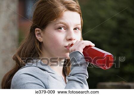 Stock Photo - A teenage girl drinking alcopops. Fotosearch
