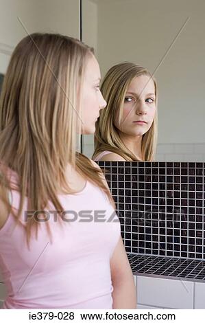 A teenage girl looking in a mirror View Large Photo Image Stock Photo - A teenage girl looking in a mirror. Fotosearch