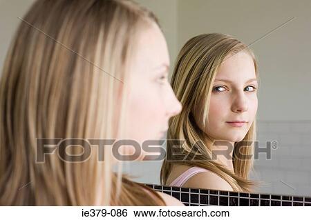 A teenage girl looking in a mirror View Large Photo Image Stock Photograph - A teenage girl looking in a mirror. Fotosearch