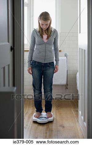 A teenage girl weighing herself View Large Photo Image Stock Photography - A teenage girl weighing herself. Fotosearch
