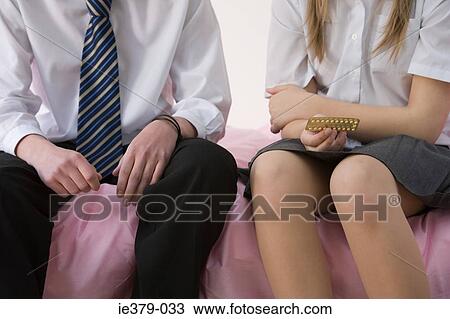 Stock Image - A young couple holding contraceptive pill . Fotosearch