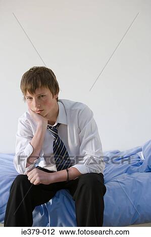 Portrait of a teenage boy sat on a bed View Large Photo Image Stock Image - Portrait of a teenage boy sat on a bed. Fotosearch